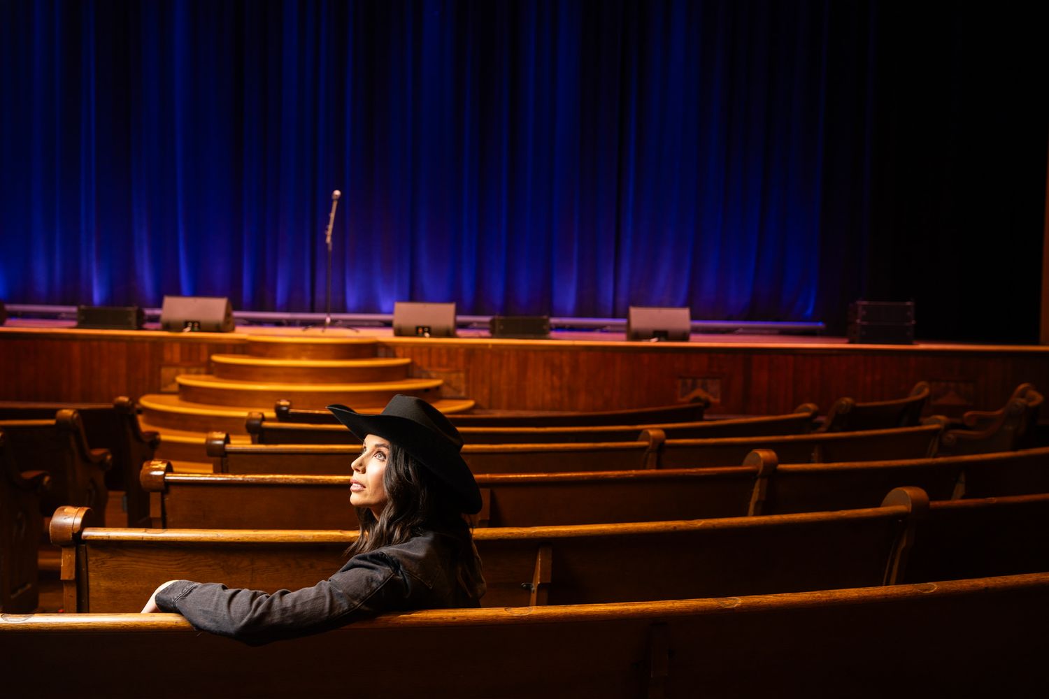 Danae alone in the pews under blue light